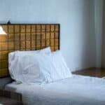 White Bedding Cover Beside Brown Wooden Side Table