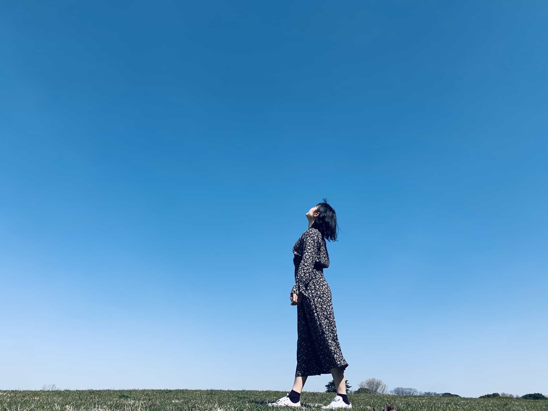 一個女人站在田野裡仰望天空。